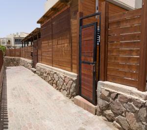 a fence with a wooden door on a building at Premium Studio Eilot Street 89B in Eilat