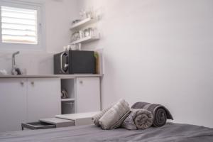 a bedroom with a bed with blankets and a tv at Premium Studio Eilot Street 89B in Eilat