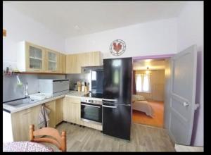 a kitchen with a black refrigerator in a room at La maison de Francis in Genouillac