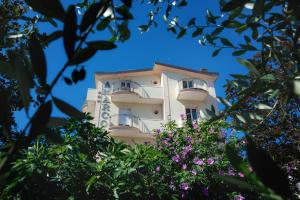 a tall building with balconies and flowers at Hotel Residence Amarcord in Rimini