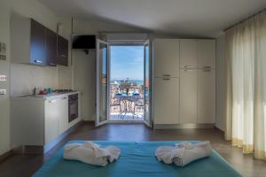 a kitchen with two towels on a blue bed in a room at Hotel Residence Amarcord in Rimini +16 photos