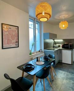 a kitchen with a table and chairs in a room at Soleil levant - T2 avec terrasse proche Gare in Amiens