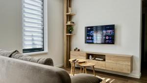 a living room with a couch and a tv at Black Lotus III l 24hr Self Check-in l City centre l Free parking in Banská Bystrica
