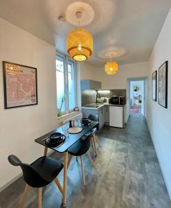 a kitchen and dining room with a table and chairs at Soleil levant - T2 avec terrasse proche Gare in Amiens
