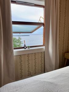 Un dormitorio con una ventana con vista al mar. en Sophiehuset- Cozy oceanview home, en Sørvågen