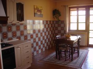 a kitchen with a table and chairs in a room at A great escape in Monforte dʼAlba