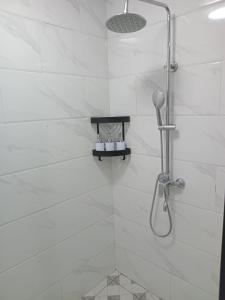 a white bathroom with a shower with a shower head at Vailoa 1bedroom, 5 min to Apia, AC, Wi-fi, kitchen in Apia