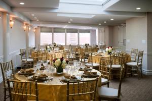 um salão de banquetes com mesas e cadeiras com pratos e flores em Hotel Lucerne em Nova York