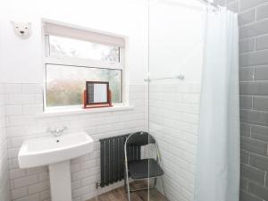 a white bathroom with a sink and a window at Seabreeze in Llandudno +24 photos