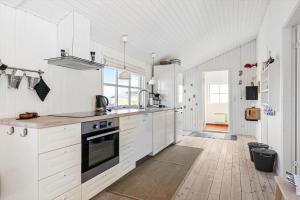 a kitchen with white cabinets and a stove top oven at TV1426-Skagen-Sostjernevej-1-B in Skagen +15 photos
