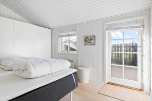a white bedroom with a bed and a window at TV1426-Skagen-Sostjernevej-1-B in Skagen