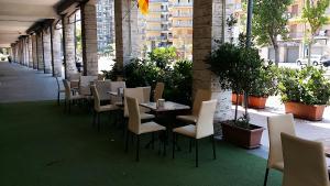 szereg stołów i krzeseł na patio w obiekcie Aparthotel TURNONE w mieście Tarent