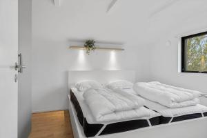 a white room with two beds with white pillows at TV1573-Albaek-Musvagevej-268 in Ålbæk