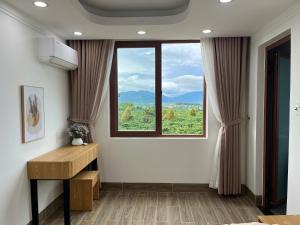 Bien HoにあるPleiku Adventures Homestayの窓、デスク、テーブルが備わる客室です。