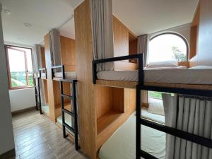 Bien HoにあるPleiku Adventures Homestayの二段ベッド3台と窓のある部屋