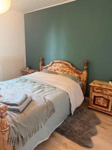 a bed in a bedroom with a blue wall at La chambre clé de la forêt in Métairies-Saint-Quirin