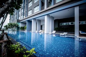 a swimming pool next to a building at Baan Kiang Fah Apartment by Patcha in Hua Hin