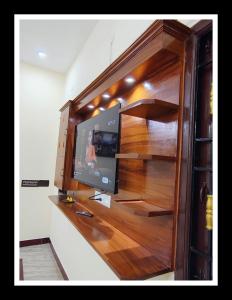 a flat screen tv in a wooden entertainment center at Relax inn villa 3BHK in Puducherry +12 photos