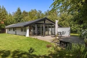 ein weißes Haus mit einem schwarzen Dach in der Unterkunft TV1529 Jerup - Blåbærvej 3 in Jerup