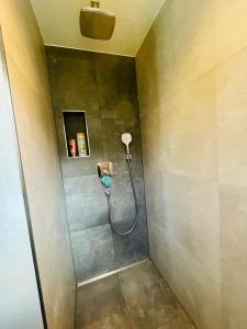 a shower with a hose attached to a wall at Urlaub im fränkischen Seenland in Allersberg