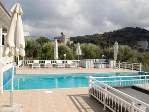 a swimming pool with chairs and umbrellas next to at Villa in Sisi near Beach & Olive Groves in Milatos +20 photos