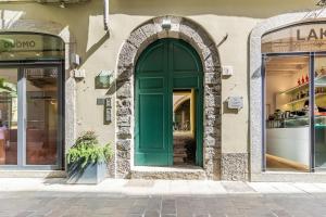 Duomo 3 Floors Penthouse في كومو: باب أخضر على جانب المبنى