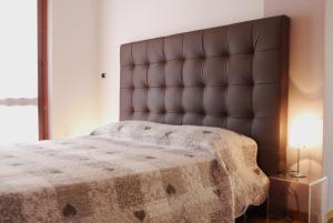 a bedroom with a large bed with a brown headboard at Beija-Flor b&b in Verano Brianza