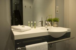 a bathroom with a sink with towels and a mirror at Hotel Le Clos De La Prairie in Gouy-Saint-André