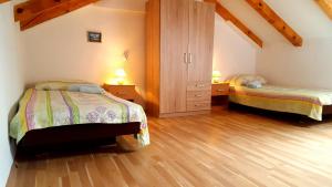 1 dormitorio con 2 camas en una habitación con suelo de madera en Apartment Nevenka, en Medulin