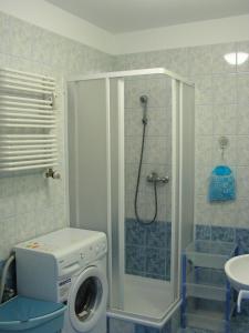 een badkamer met een douche en een wasmachine bij Apartament Paula in Ustka