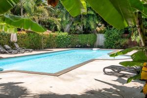 a swimming pool in a yard with chairs and trees at Seetanu Bungalows in Srithanu