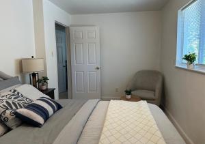 a bedroom with a bed and a chair and a window at Suite E with 2-bedroom in Sacramento