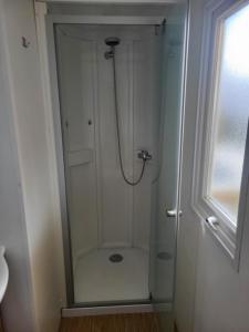 a white shower with a hose in a bathroom at Mobil-home chez MG in Sérignan +14 photos