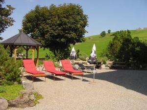 eine Gruppe roter Stühle und ein Pavillon in der Unterkunft Hotel Restaurant Belvedere in Weissbad