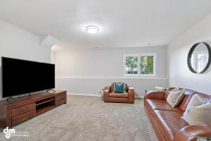 a living room with a couch and a flat screen tv at Modern Turnagain Townhome in Anchorage