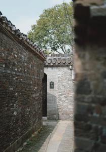 an alley with a brick wall and a door at Persimmon Restaurant Yangzhou Dongguan Street Branch in Yangzhou