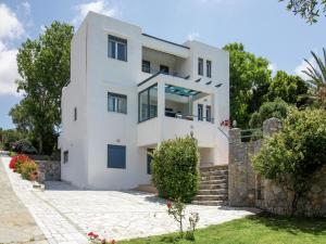 a white house with a stone wall at Villa in Lefkogia near Souda Beach in Lefkogeia