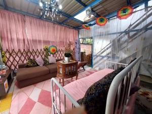 a living room with a bed and a couch at Cassa Bonda Tiny Studio in Kampong Bakat