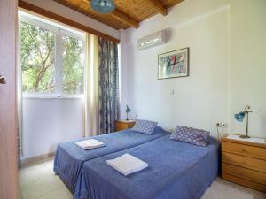 a bedroom with two beds and a window at Villa in Lefkogia near Souda Beach in Lefkogeia