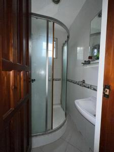 a bathroom with a glass shower and a sink at Lustria White Castle in Iloilo City