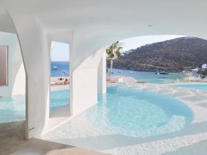 a swimming pool with a view of the ocean at Mykonos Blu, a Resort to Live in Psarou