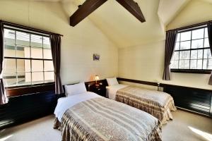 ein Schlafzimmer mit zwei Betten und zwei Fenstern in der Unterkunft Petit Hotel Kanan in Chino
