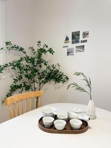 a table with a plate with four bowls and a vase at Adam stay in Suyŏng