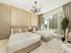 a bedroom with two beds and a large window at Luxury Stay in Downtown-Steps to Burj & Dubai Mall in Dubai +55 photos