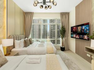 a bedroom with two beds and a flat screen tv at Luxury Stay in Downtown-Steps to Burj & Dubai Mall in Dubai