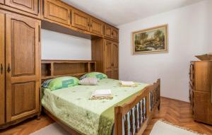a bedroom with a bed and a wooden cabinet at Holiday home - Apartments Marinjo in Stinica +29 photos