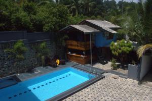 a swimming pool in front of a building with a house at New View Hikkaduwa in Hikkaduwa