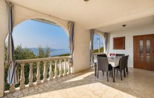 a dining room with a table and a balcony at Holiday home - Apartments Marinjo in Stinica