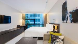 a hotel room with a bed and a couch at Maitria Hotel Sukhumvit 18 Bangkok – A Chatrium Collection in Bangkok