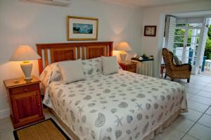 a bedroom with a bed and two lamps and a chair at The Knysna Belle Guest House in Knysna